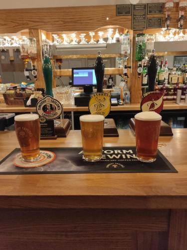 three glasses of beer on a tray on a bar at The Thorold in Marston