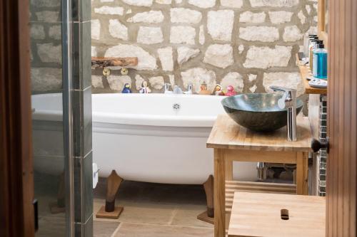 a bathroom with a bath tub and a sink at Crow House Barn in Copgrove