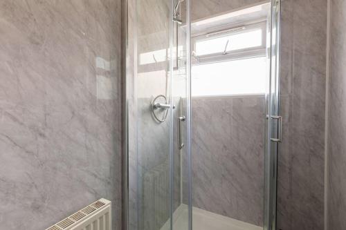 a shower with a glass door in a bathroom at Midwood Lodge in Manchester