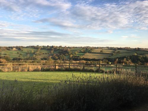 um campo de relva verde com um céu nublado em Harrogate Barns em Harrogate