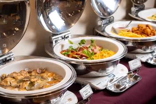 a table topped with plates of food and bowls of food at Daiwa Roynet Hotel Okinawa-Kenchomae in Naha