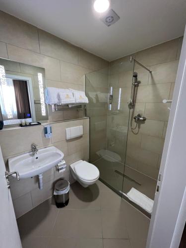a bathroom with a shower and a toilet and a sink at 3A Hotel 