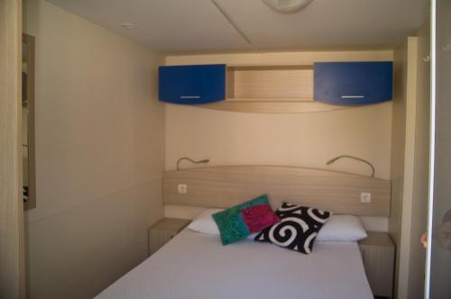 Camping & Village Polvese في Sant Arcangelo: غرفة نوم صغيرة مع سرير ودواليب زرقاء