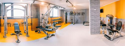 a gym with yellow walls and tread machines at Mandachi Hotel & SPA in Suceava