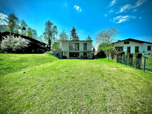 a large yard with a house in the background at 100m2 Haus am See & Wald mit 1200m2 Garten in Schwielowsee