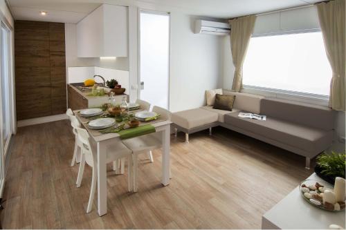 cocina y sala de estar con mesa y sillas en Piani di Clodia Holidaypark, en Lazise