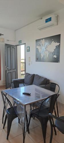 uma mesa e cadeiras numa sala de estar com um sofá em Sol y Malbec Departamentos em Guaymallén