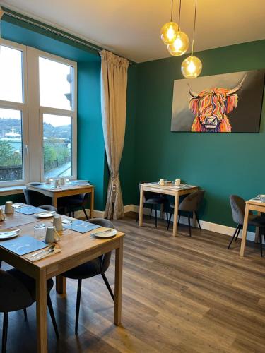 un comedor con mesas y una pintura de tigre en la pared en Killorn Guest House, en Oban