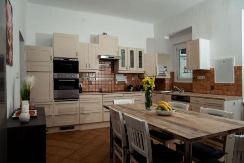eine Küche mit einem Holztisch und eine Küche mit weißen Schränken in der Unterkunft Bessemer in Wien
