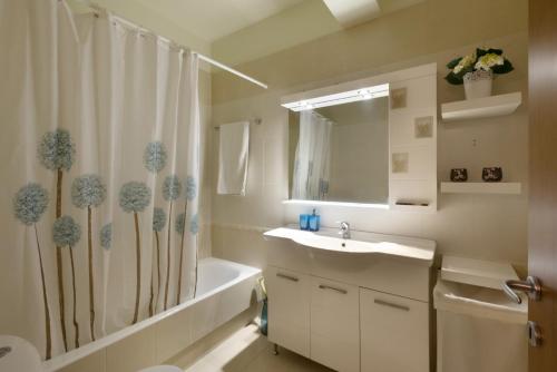łazienka z umywalką i zasłoną prysznicową w obiekcie 3BR Prime APT a breath away from the Acropolis! w Atenach