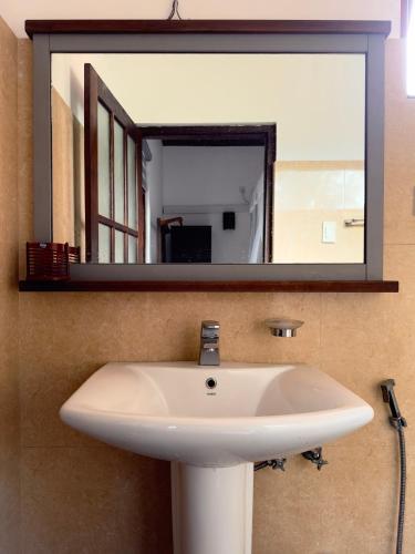 a bathroom sink with a large mirror above it at Tanzanite place in Tangalle
