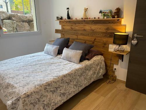 - une chambre avec un lit et une tête de lit en bois dans l'établissement Les écureuils, à Xonrupt-Longemer