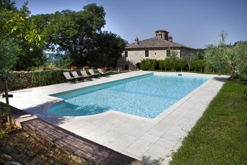 uma piscina com cadeiras num quintal em Agriturismo Tenuta Armaiolo em Rapolano Terme