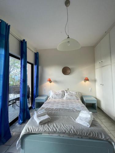 a bedroom with a large bed with blue curtains at Tersanas Beach Apartments in Chorafakia