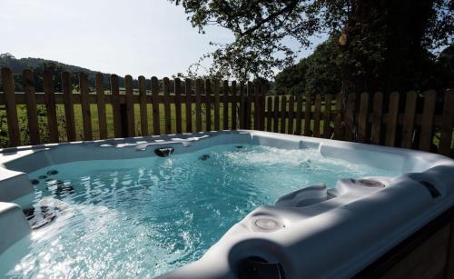 a hot tub in front of a wooden fence at The Garage in Welshpool