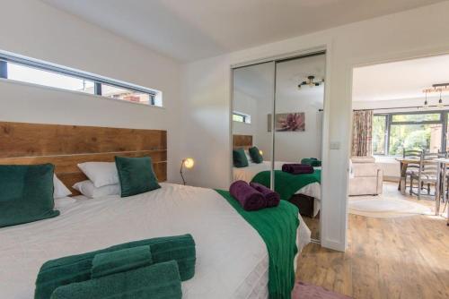 ein Schlafzimmer mit einem großen weißen Bett mit grünen Akzenten in der Unterkunft The Garage in Welshpool