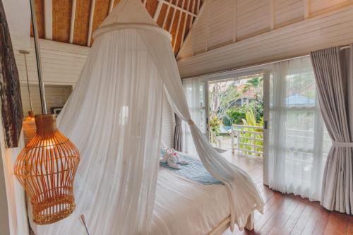 a bed in a room with a hammock at Shrining Cottages Lembongan in Nusa Lembongan
