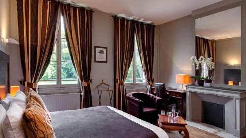 een slaapkamer met een bed, een bureau en een open haard bij Le Pavillon De Gouffern in Silli-en-Gouffern