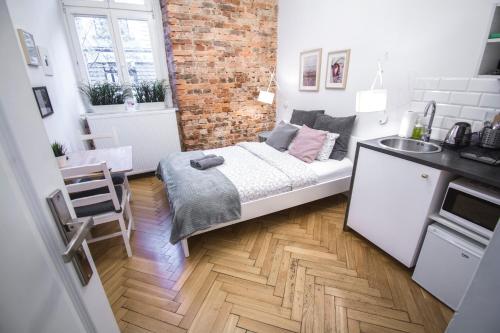 Habitación pequeña con cama y pared de ladrillo en LION apartments en Cracovia