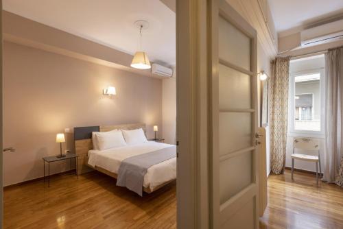 a bedroom with a bed and a door open at Prime Location 2 BR APT next to the Acropolis in Athens