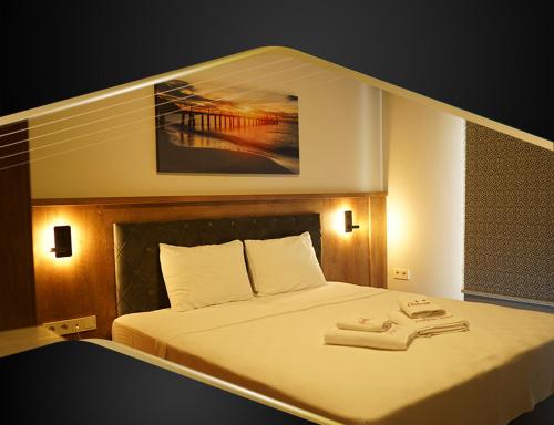 a bedroom with a bed with two towels on it at GRAND ÇAYKARAM HOTEL in Çaykara