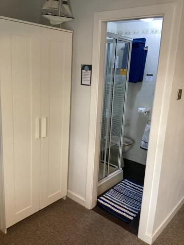a bathroom with a shower with a glass door at By the Seaside in Blackpool