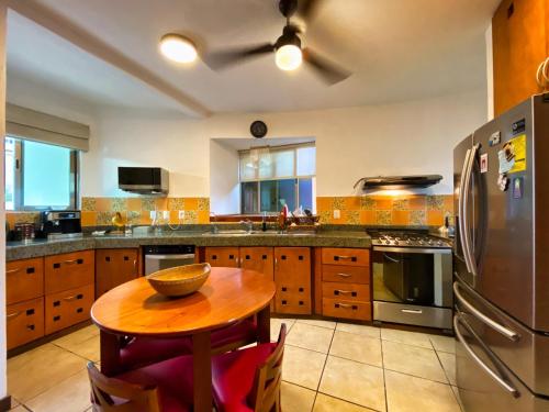 a kitchen with a wooden table and a refrigerator at Humant Coliving - Cancún in Cancún