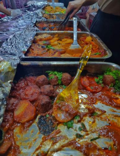a buffet line of trays of food with utensils at White Desert Camp in Wadi Rum