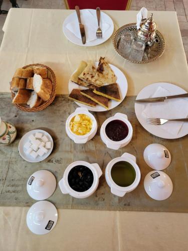 a table topped with plates and bowls of food at Hotel la Perle d'Arfoud in Erfoud