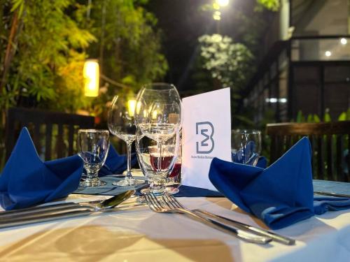 a table with three wine glasses and blue napkins at Bayon Modern Residence in Siem Reap