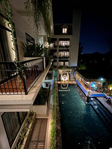 a building with a swimming pool at night at Bayon Modern Residence in Siem Reap