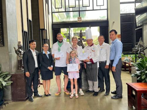 a group of people posing for a picture in a restaurant at Bayon Modern Residence in Siem Reap