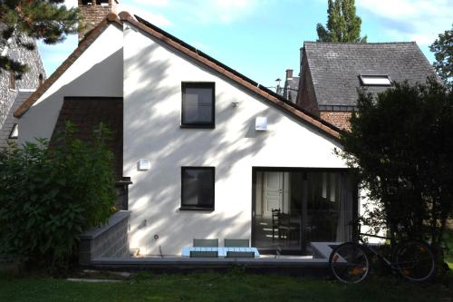 那慕爾的住宿－Au four et au jardin，前面有两长椅的白色房子