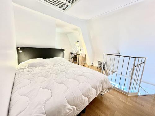 a white bed in a white room with a glass floor at Le Castel 1 C.L.S Deauville in Deauville