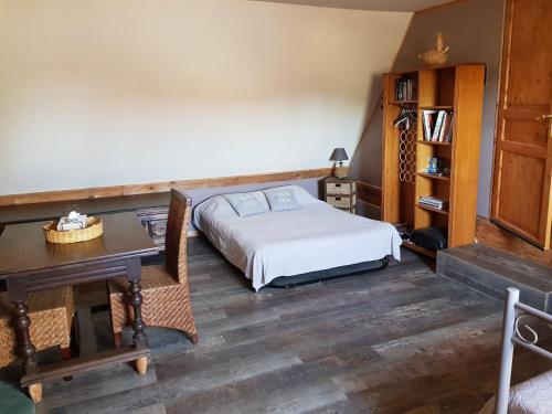 a bedroom with a bed and a desk and a table at Val de Gée in Maigné