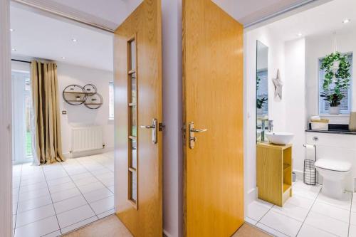 y baño con aseo y lavamanos. en Luxurious Cosy 4BR Home Cheshire, en Saughall