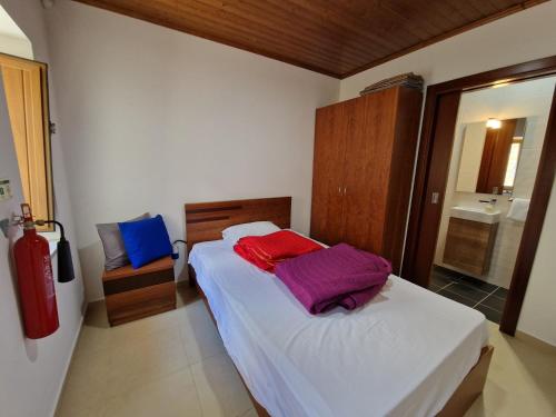 a bedroom with a bed with white sheets and purple sheets at Cascata do Varosa - Turismo Rural in Vila Pouca