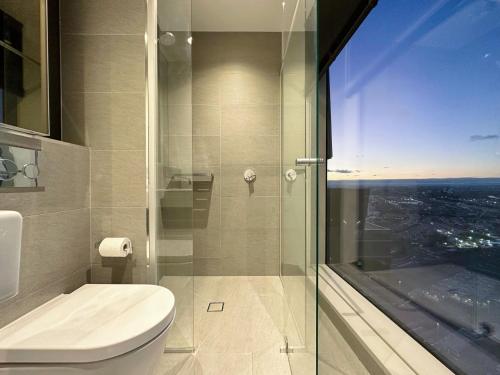 a bathroom with a toilet and a glass shower at Melbourne CBD Apt with Free Car Park Ocean View in Melbourne
