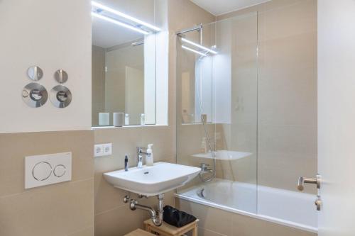 een badkamer met een wastafel, een douche en een bad bij Apartment zum Genießen in Garmisch-Partenkirchen