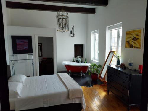 a bedroom with a bed and a tub and a sink at Rooftop Heated Jacuzzi, Fireplace, A Unique Home! in Żebbuġ