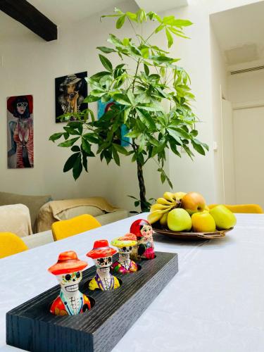 a table with three figurines on it with a plate of fruit at Rooftop Heated Jacuzzi, Fireplace, A Unique Home! in Żebbuġ