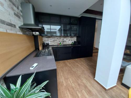 a kitchen with black cabinets and a counter top at Rooftop Heated Jacuzzi, Fireplace, A Unique Home! in Żebbuġ