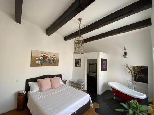 - une chambre avec un lit et une baignoire dans l'établissement Rooftop Heated Jacuzzi, Fireplace, A Unique Home!, à Żebbuġ