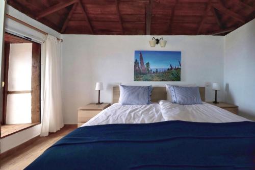 una camera da letto con un letto con lenzuola blu e una finestra di Casa Demetria La Palma a Puntagorda