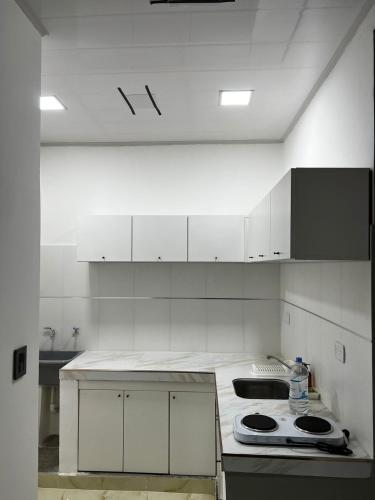 a kitchen with white cabinets and a stove top oven at EDIFICIO BETEL in Salvador Mazza
