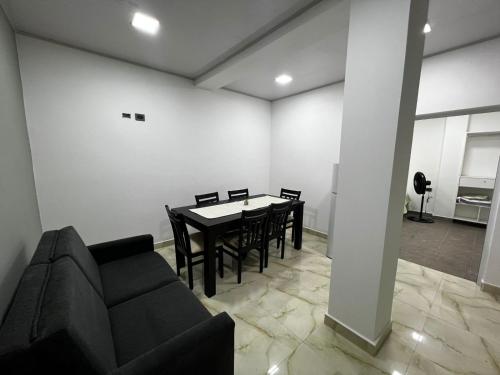 a dining room with a table and chairs and a couch at EDIFICIO BETEL in Salvador Mazza