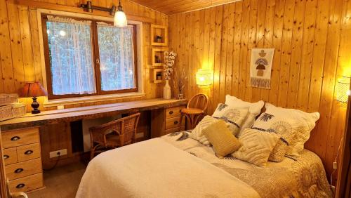 a bedroom with a bed in a wooden room at Chalet « à l’orée du bois » in Liézey