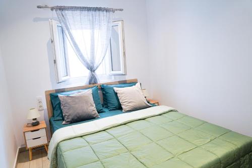 a bed in a bedroom with a window at SunStone Apartment in Fira