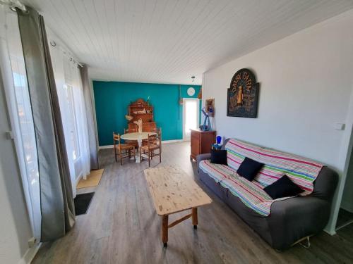 un salon avec un canapé et une table dans l'établissement La Cabane de Chantovan ~ 300m de l'océan, à Mimizan