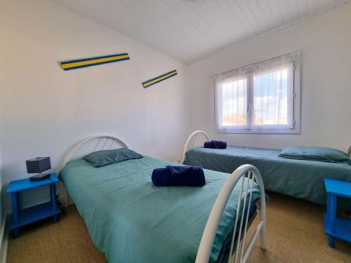 une chambre avec deux lits et une fenêtre dans l'établissement La Cabane de Chantovan ~ 300m de l'océan, à Mimizan